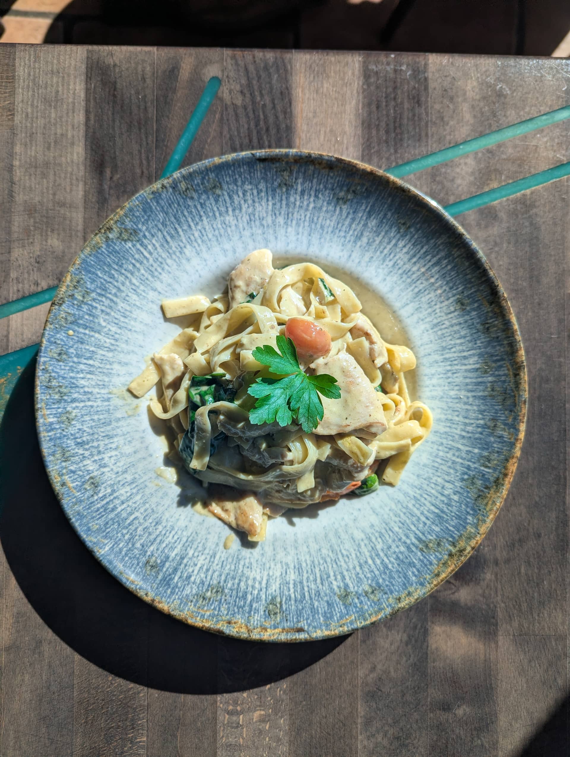 Pasta Verde — Tagliatelle in Pesto-Sahne-Soße mit Hähnchenbruststreifen, Cherrytomaten und Bab bei Kaspio in Stade