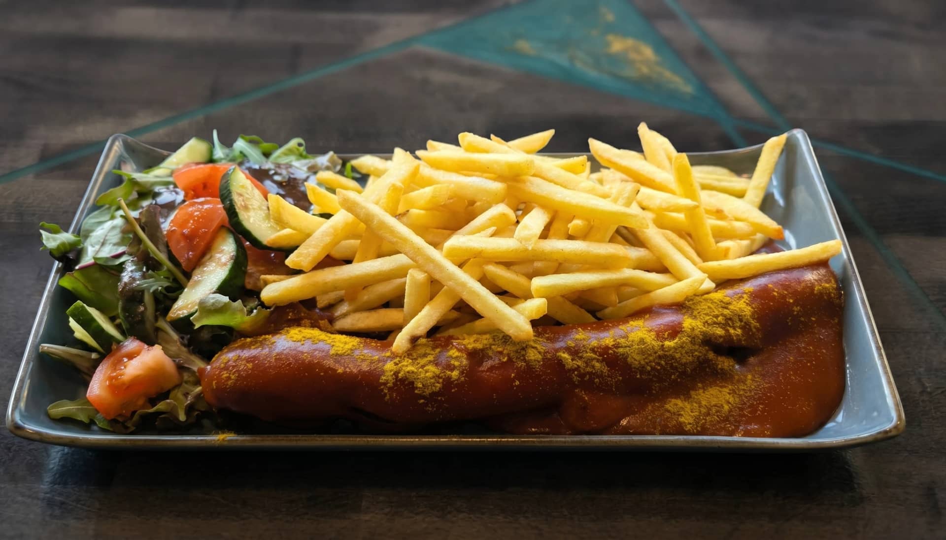 Currywurst — Große Currywurst mit Pommes und Salatbeilage bei Kaspio in Stade